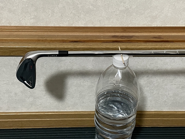クラブを水平にして重心位置を図っている様子。ペットボトルの上に爪楊枝を水平に貼って支点を作っている