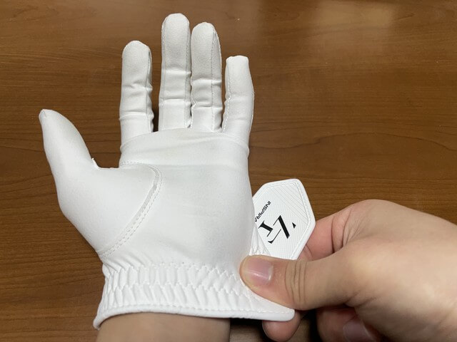 ［ゴルフグローブの着け方］小指側の裾の部分をずらして手のひらを全部入れる