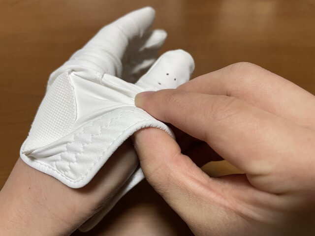 ［ゴルフグローブの外し方］親指の付け根が出るように裾をまくる